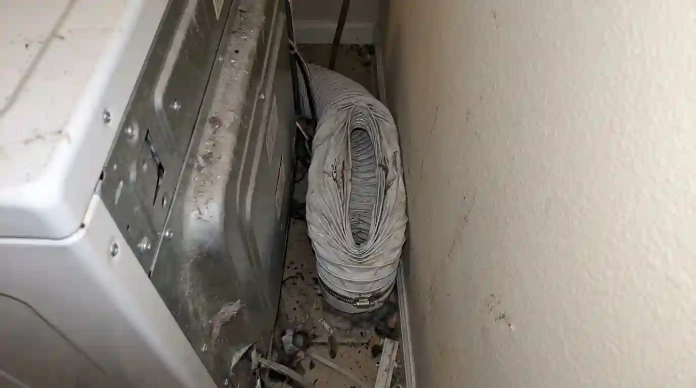 Crushed vinyl transition hose behind a dryer