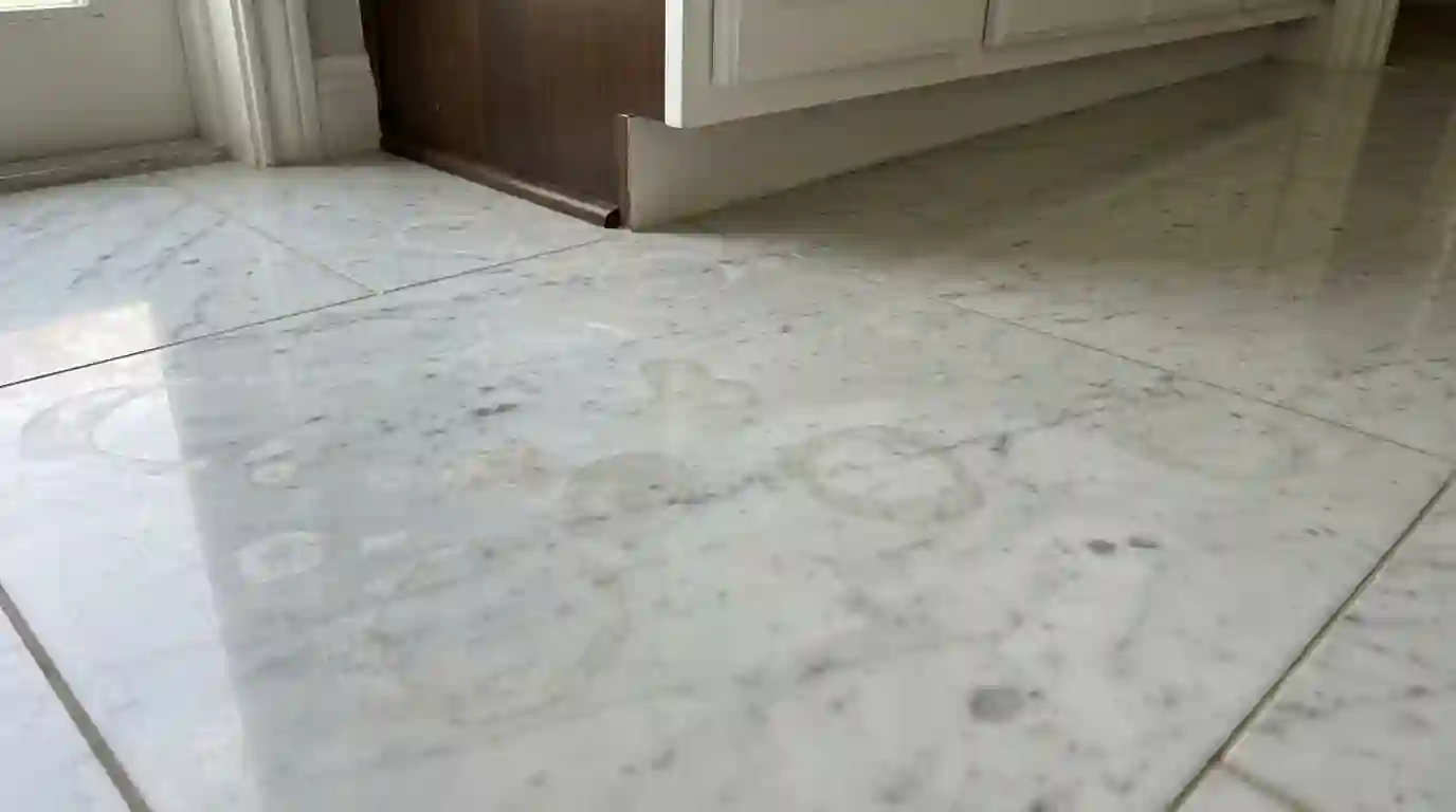 Marble bathroom floor with dull etch rings near the vanity